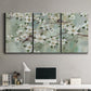 Three-panel canvas wall art featuring delicate spring blossoms with birds, displayed above a desk in a home office.