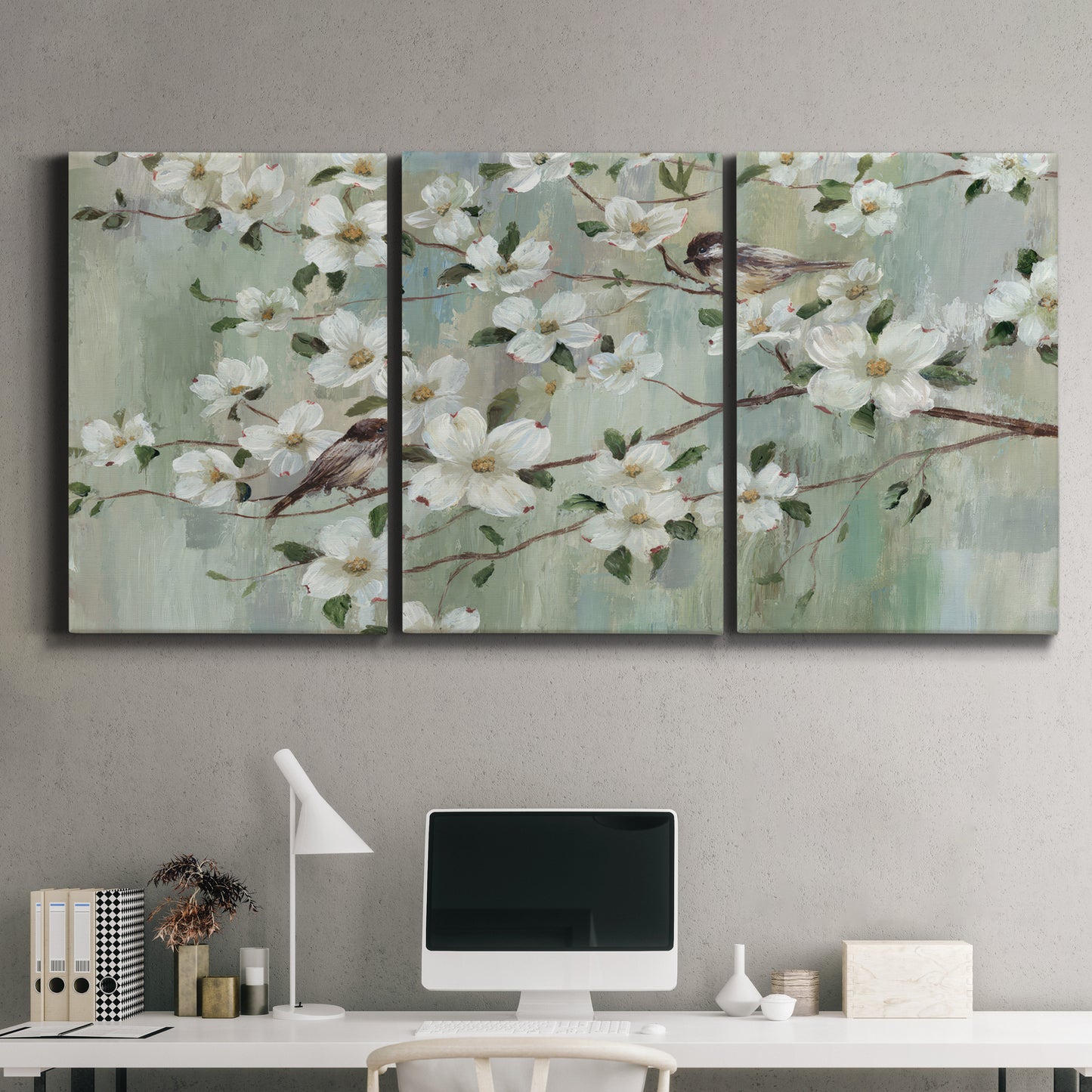 Three-panel canvas wall art featuring delicate spring blossoms with birds, displayed above a desk in a home office.