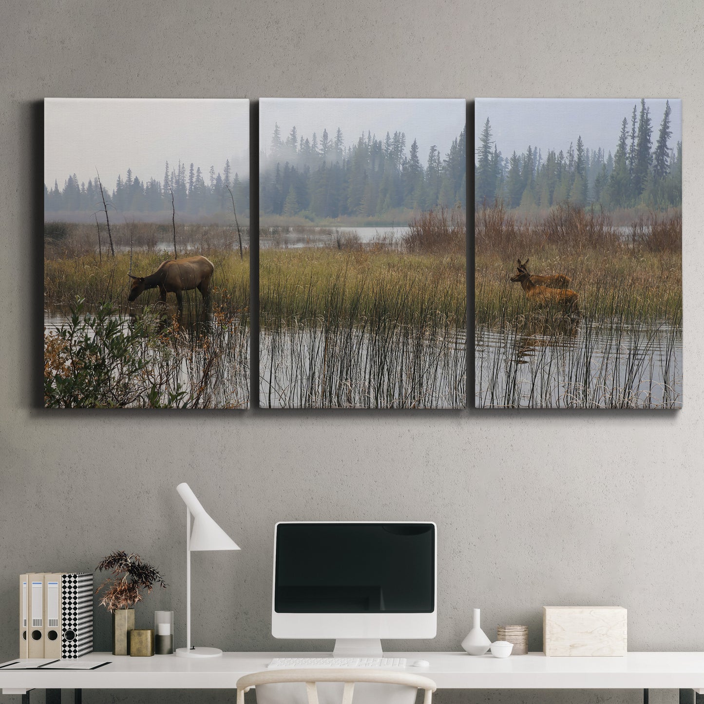 Three-panel canvas wall art featuring wildlife walking through open field, displayed above a desk in a home office.