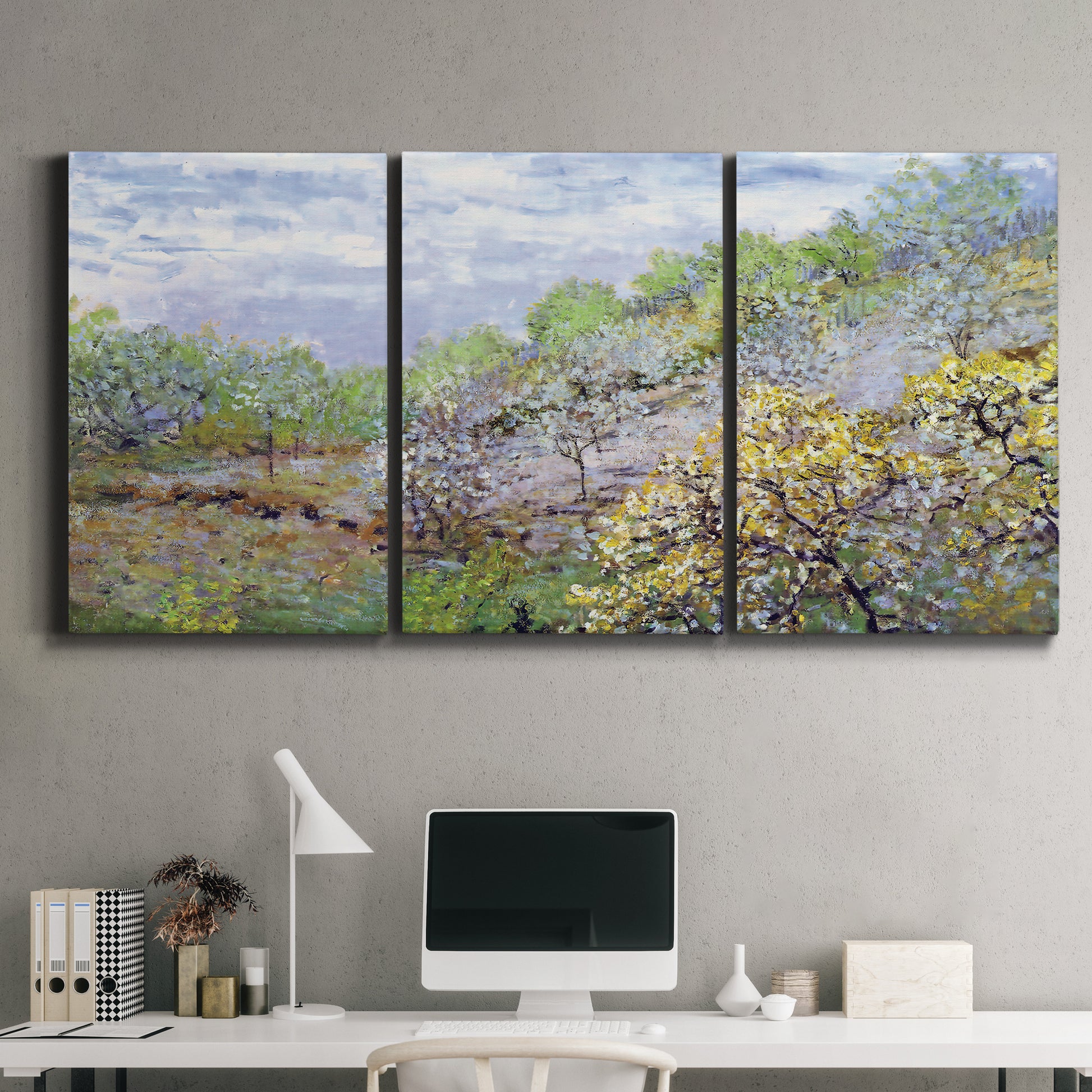 Three-panel canvas wall art featuring spring orchard in full bloom, displayed above a desk in a home office.