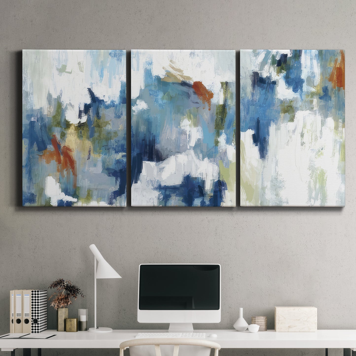 Three-panel canvas wall art featuring flowing abstract color movement, displayed above a desk in a home office.