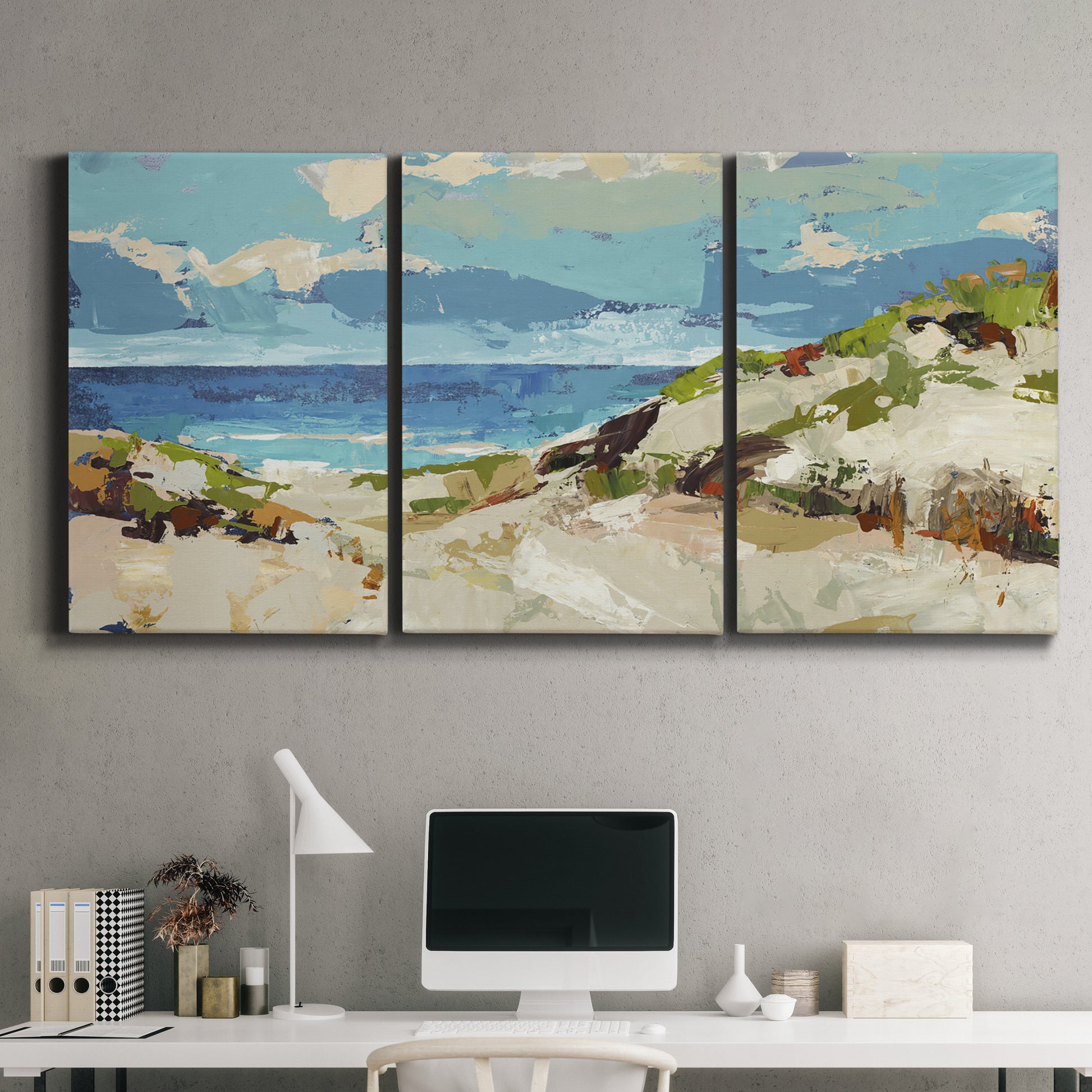 Three-panel canvas wall art featuring sand dunes beside open water, displayed above a desk in a home office.
