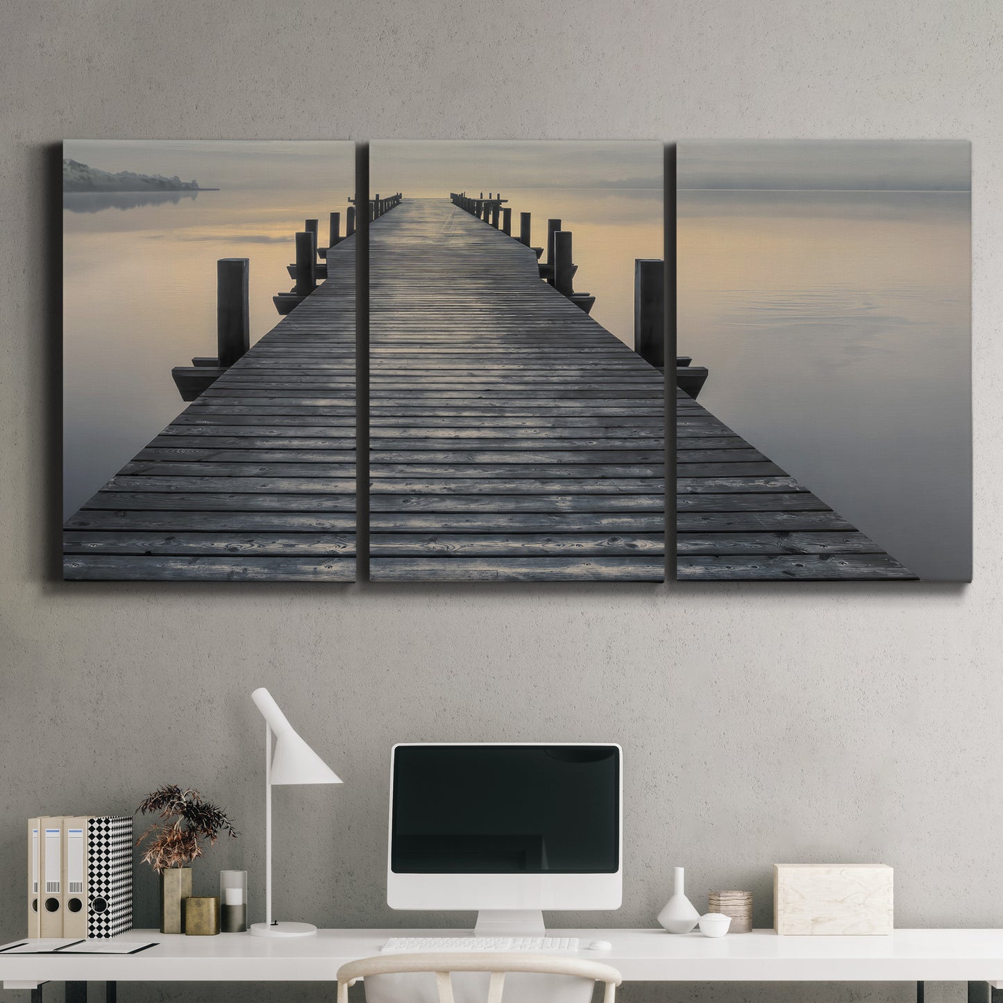 Three-panel canvas wall art featuring sunset over water photograph, displayed above a desk in a home office.