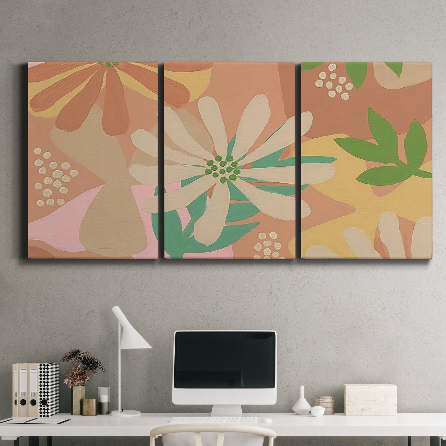 Three-panel canvas wall art featuring neutral toned botanical floral silhouettes, displayed above a desk in a home office.