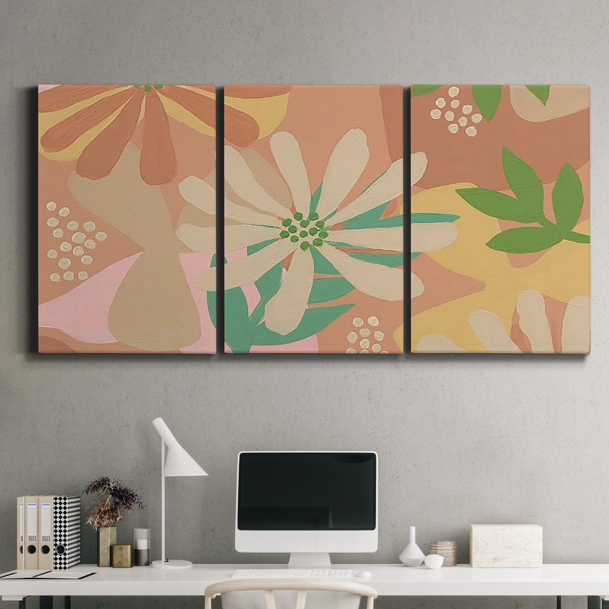 Three-panel canvas wall art featuring neutral toned botanical floral silhouettes, displayed above a desk in a home office.