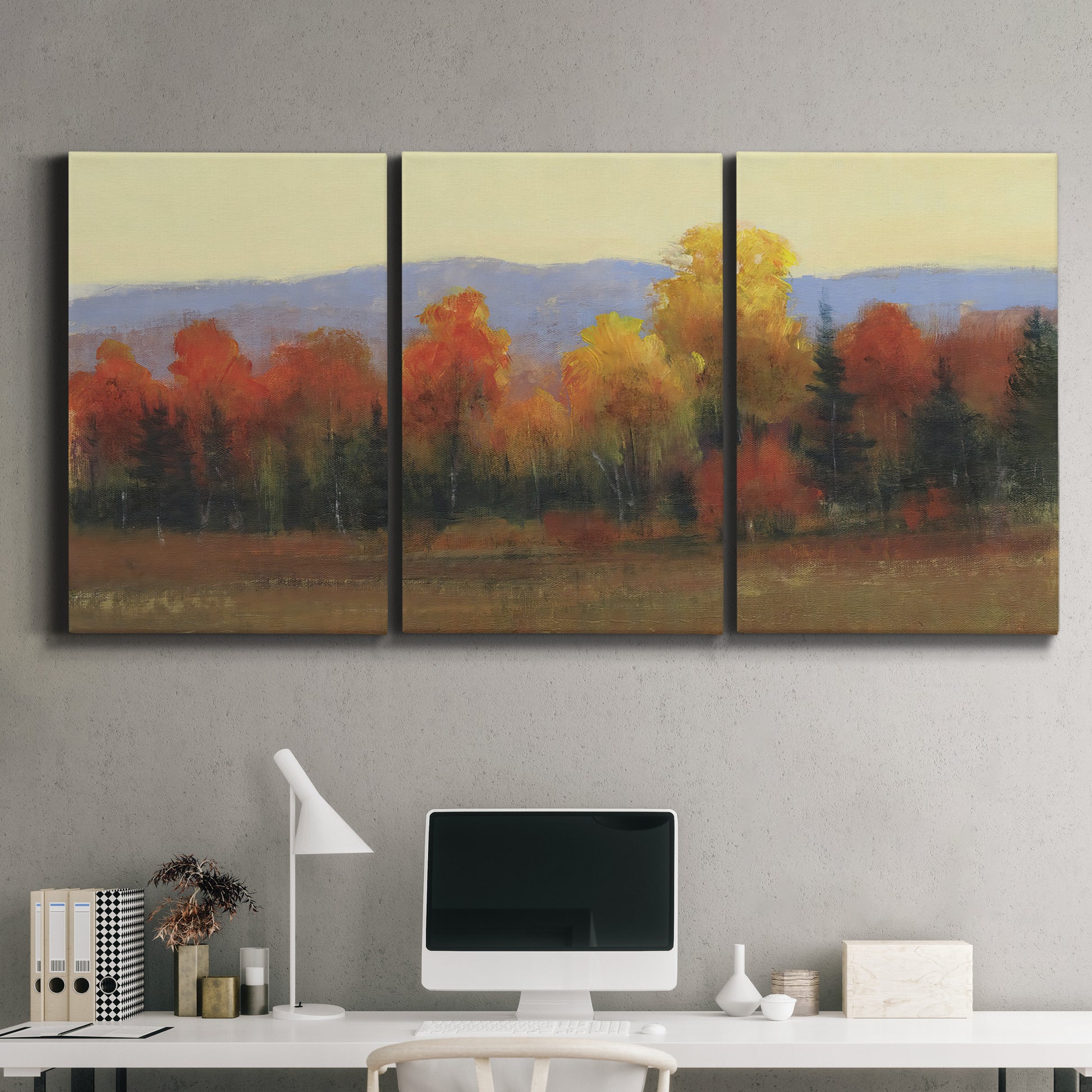 Three-panel canvas wall art featuring autumn landscape changing foliage, displayed above a desk in a home office.