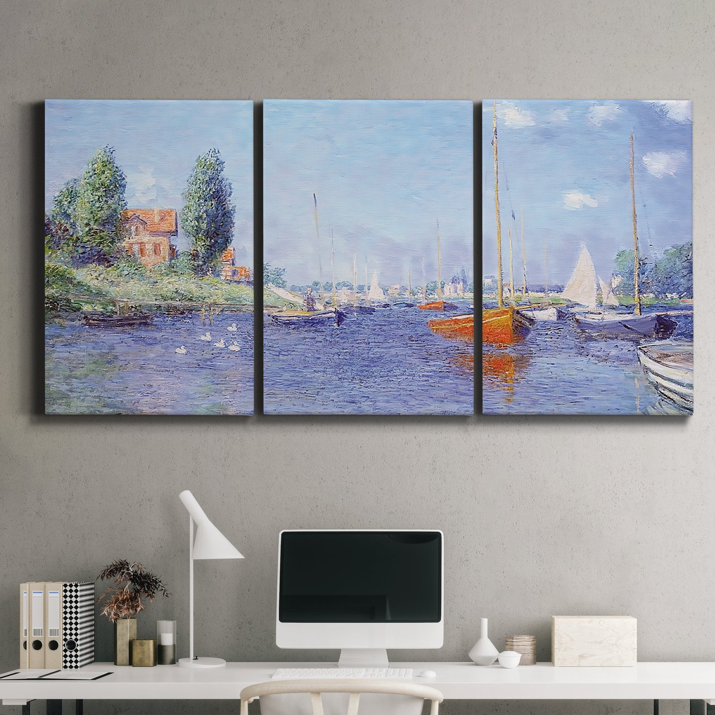 Three-panel canvas wall art featuring river flowing past riverside town, displayed above a desk in a home office.