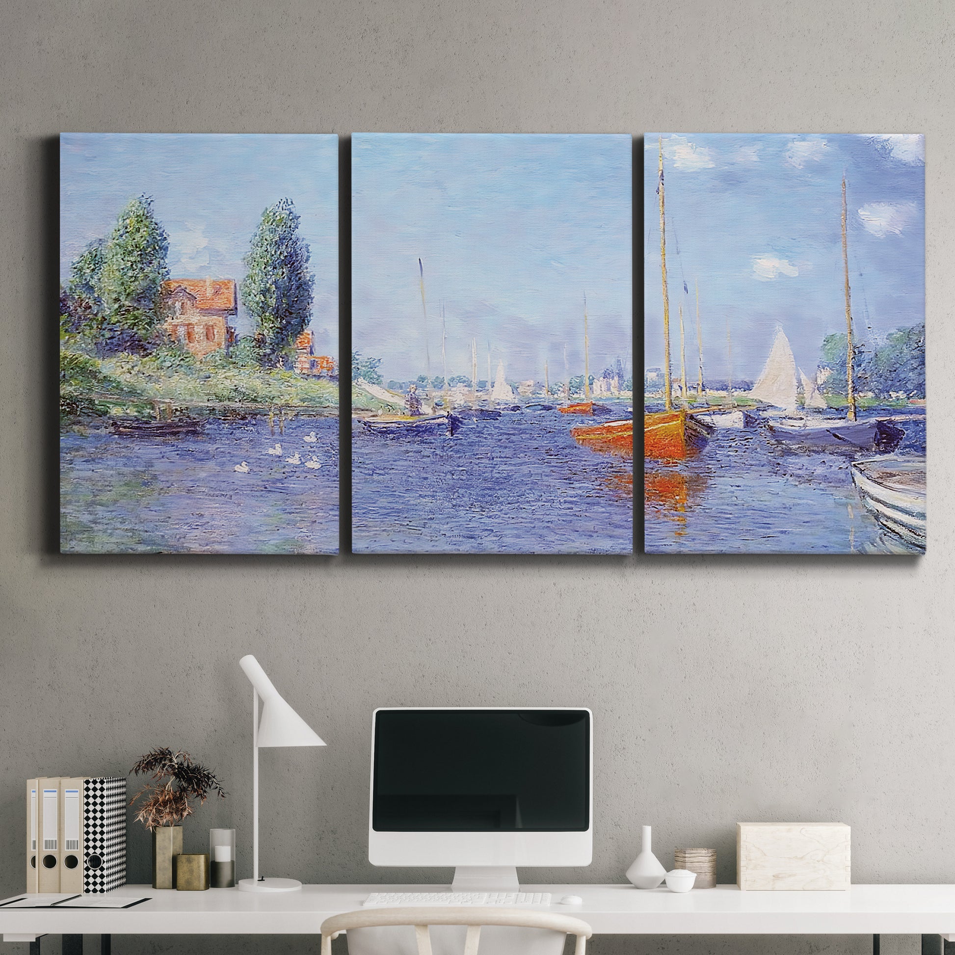 Three-panel canvas wall art featuring river flowing past riverside town, displayed above a desk in a home office.