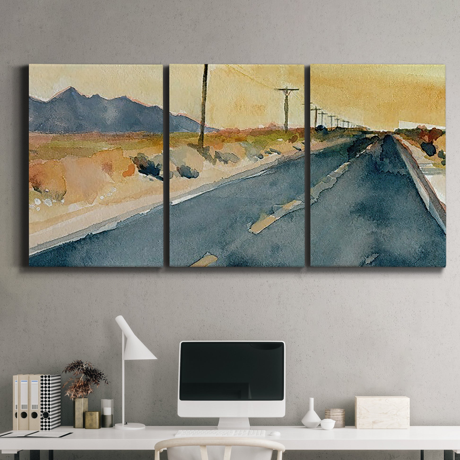 Three-panel canvas wall art featuring empty highway stretching through landscape, displayed above a desk in a home office.
