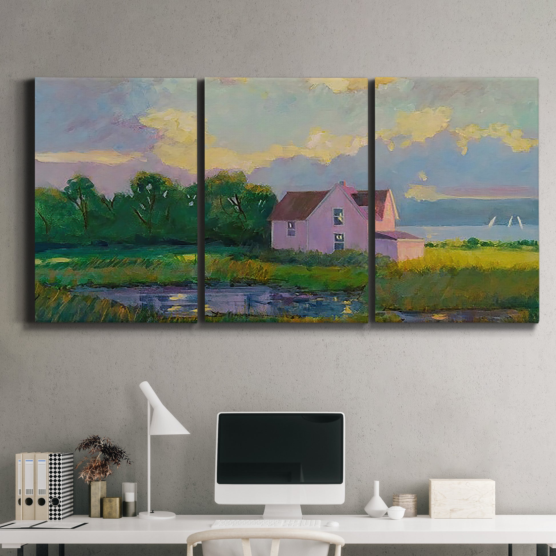 Three-panel canvas wall art featuring farmhouse near coastline landscape, displayed above a desk in a home office.
