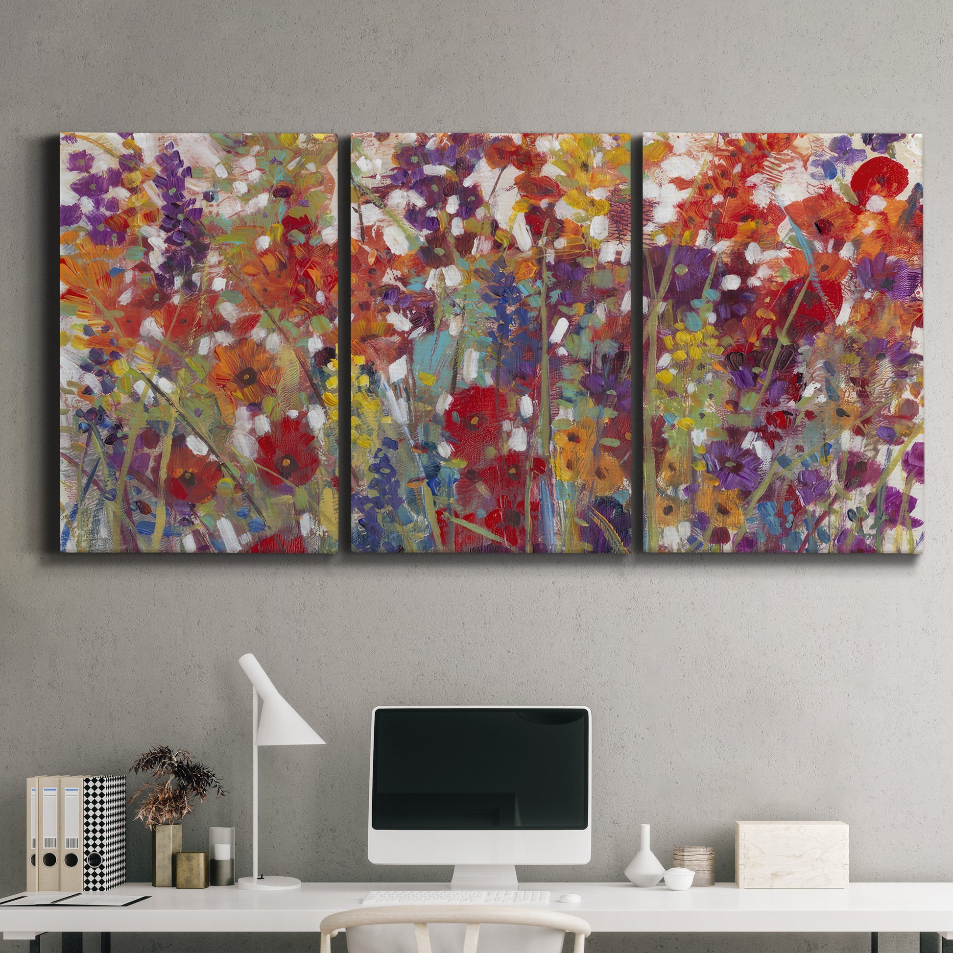 Three-panel canvas wall art featuring colorful floral arrangement, displayed above a desk in a home office.