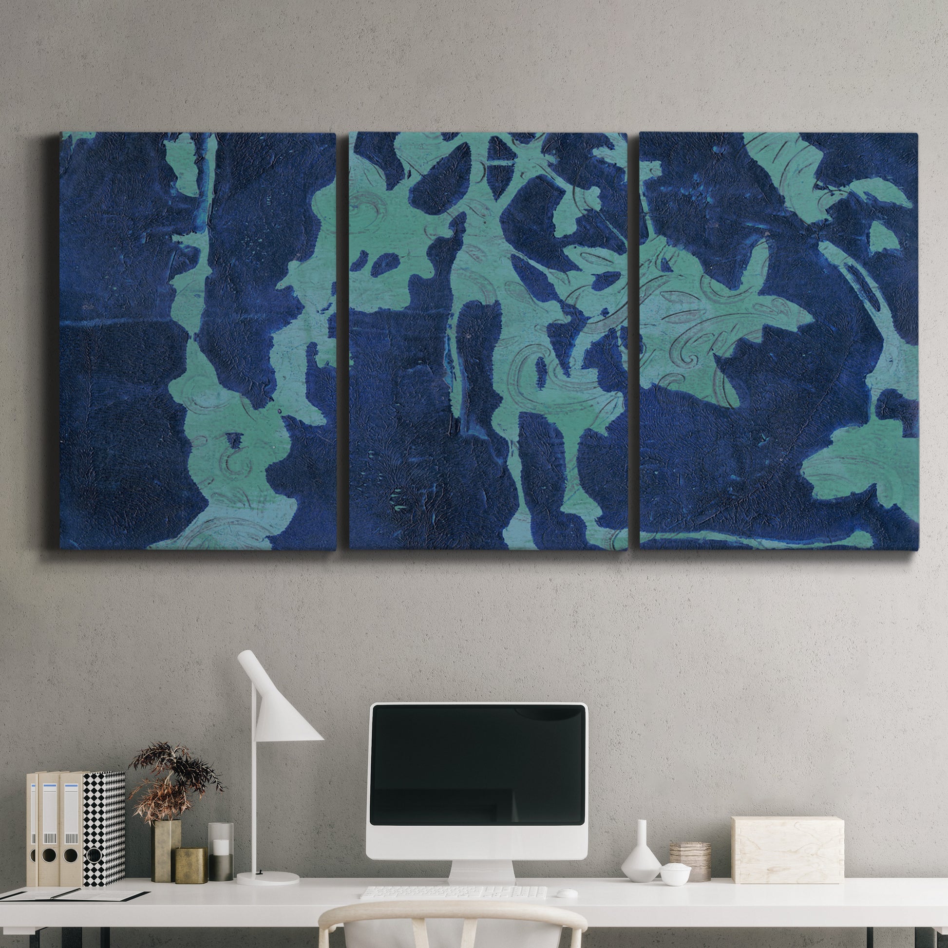 Three-panel canvas wall art featuring abstract floral shapes, displayed above a desk in a home office.