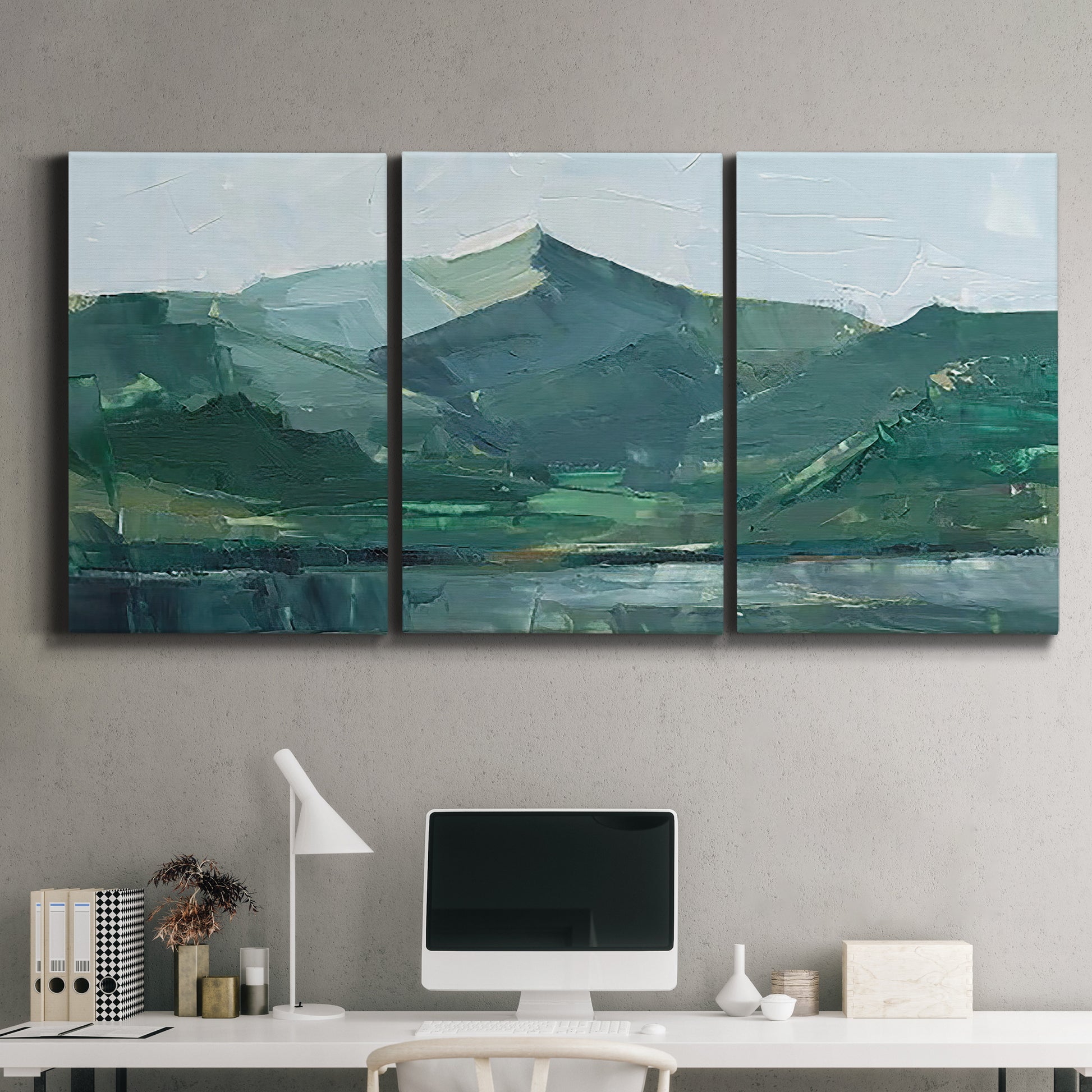 Three-panel canvas wall art featuring muted mountain range in grey tones, displayed above a desk in a home office.