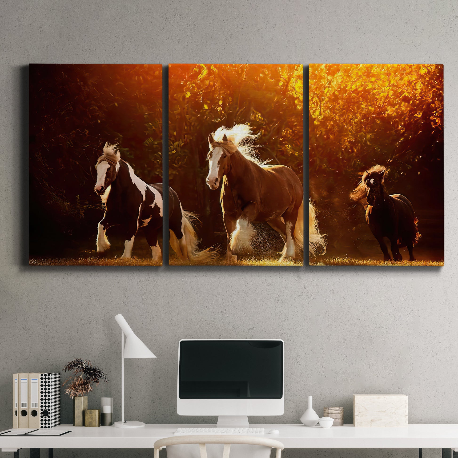 Three-panel canvas wall art featuring running horses across open field, displayed above a desk in a home office.
