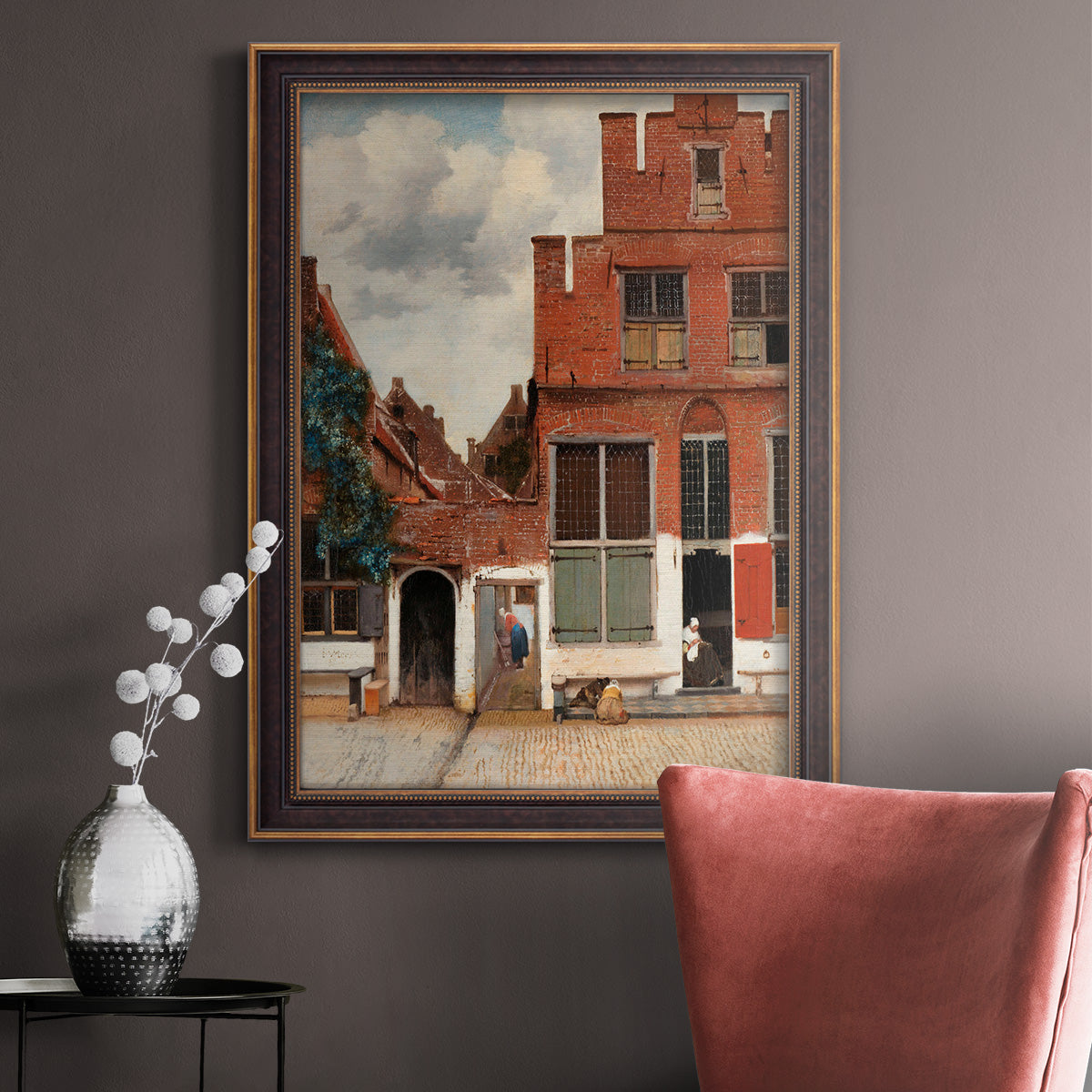Realist city street scene by Johannes Vermeer in an ornate bronzed mahogany wood frame displayed in a neutral interior setting.