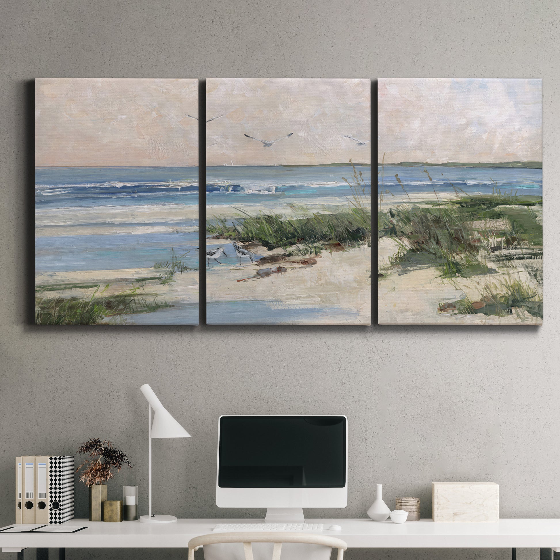 Three-panel canvas wall art featuring soft morning light over calm sea, displayed above a desk in a home office.