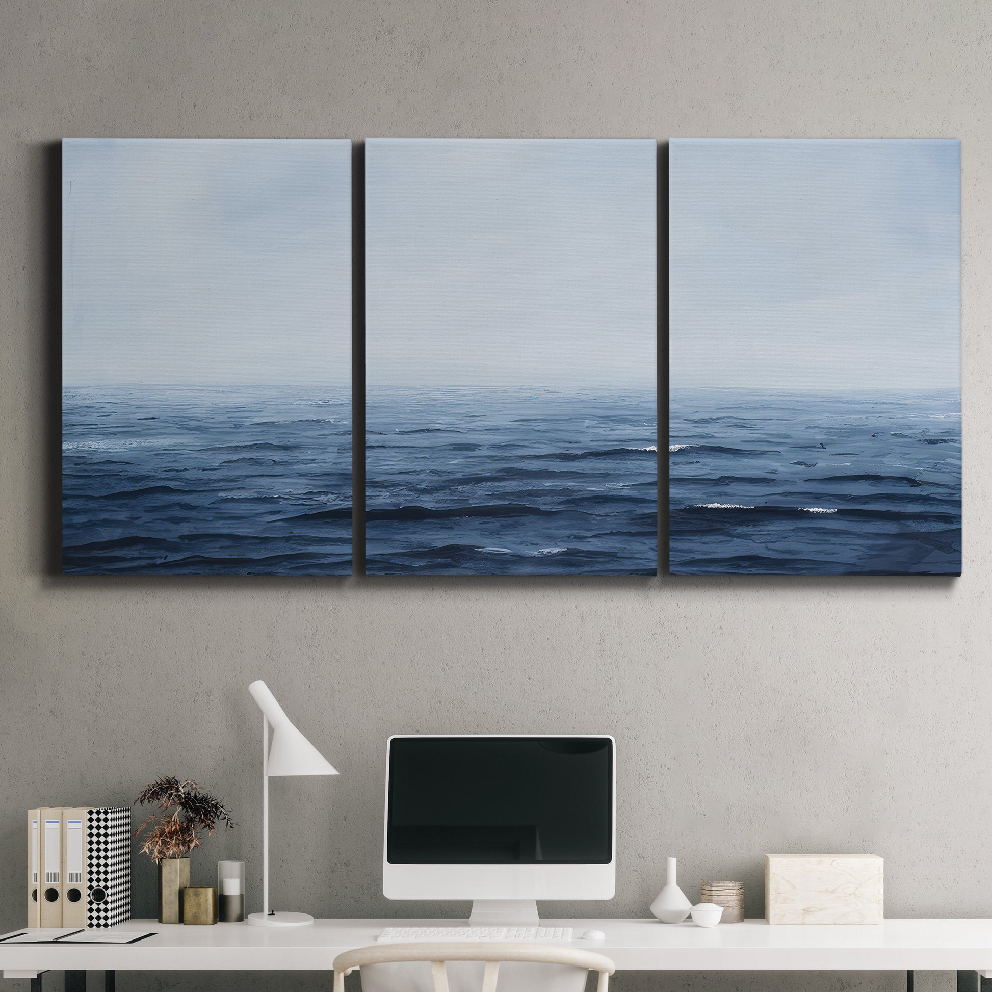 Three-panel canvas wall art featuring grayscale seascape with horizon, displayed above a desk in a home office.