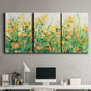 Three-panel canvas wall art featuring colorful garden flowers in bloom, displayed above a desk in a home office.
