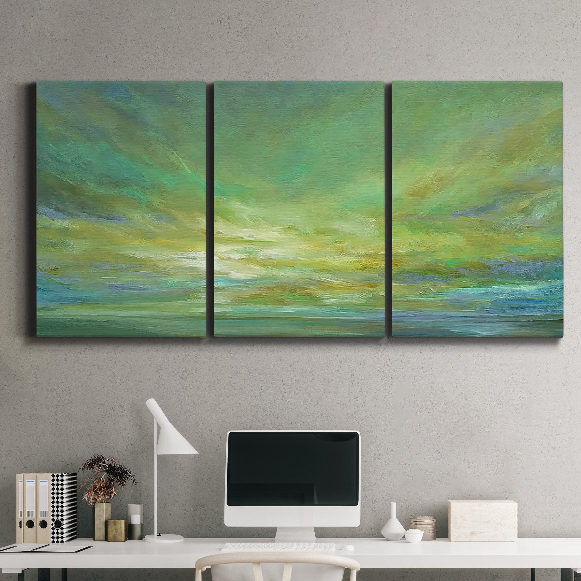 Three-panel canvas wall art featuring coastal shoreline under open sky, displayed above a desk in a home office.