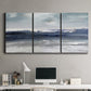 Three-panel canvas wall art featuring abstract coastal tones and movement, displayed above a desk in a home office.