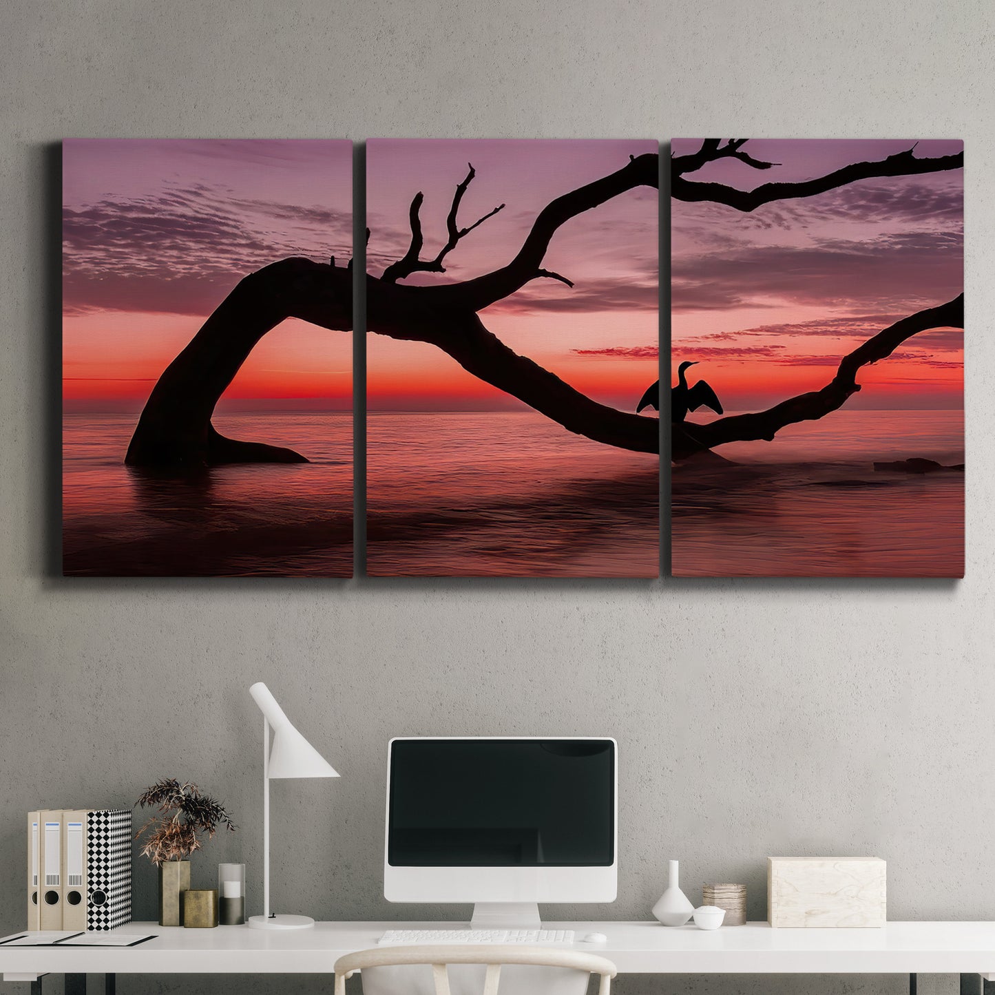 Three-panel canvas wall art featuring sunset beach photography, displayed above a desk in a home office.