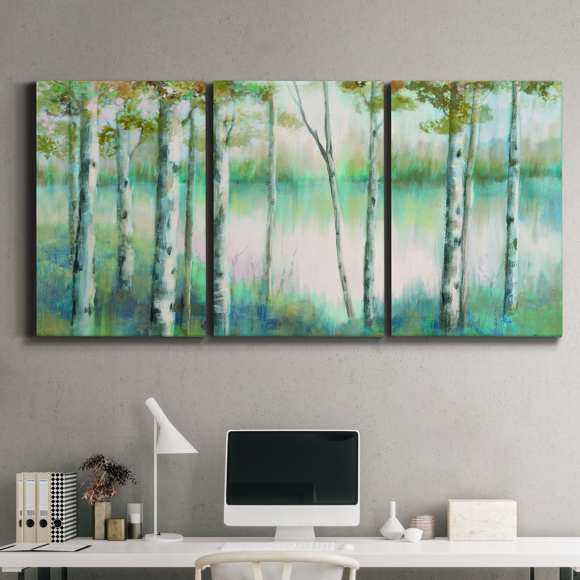 Three-panel canvas wall art featuring calm lake framed by aspen trees, displayed above a desk in a home office.