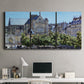 Three-panel canvas wall art featuring gothic church within city setting, displayed above a desk in a home office.
