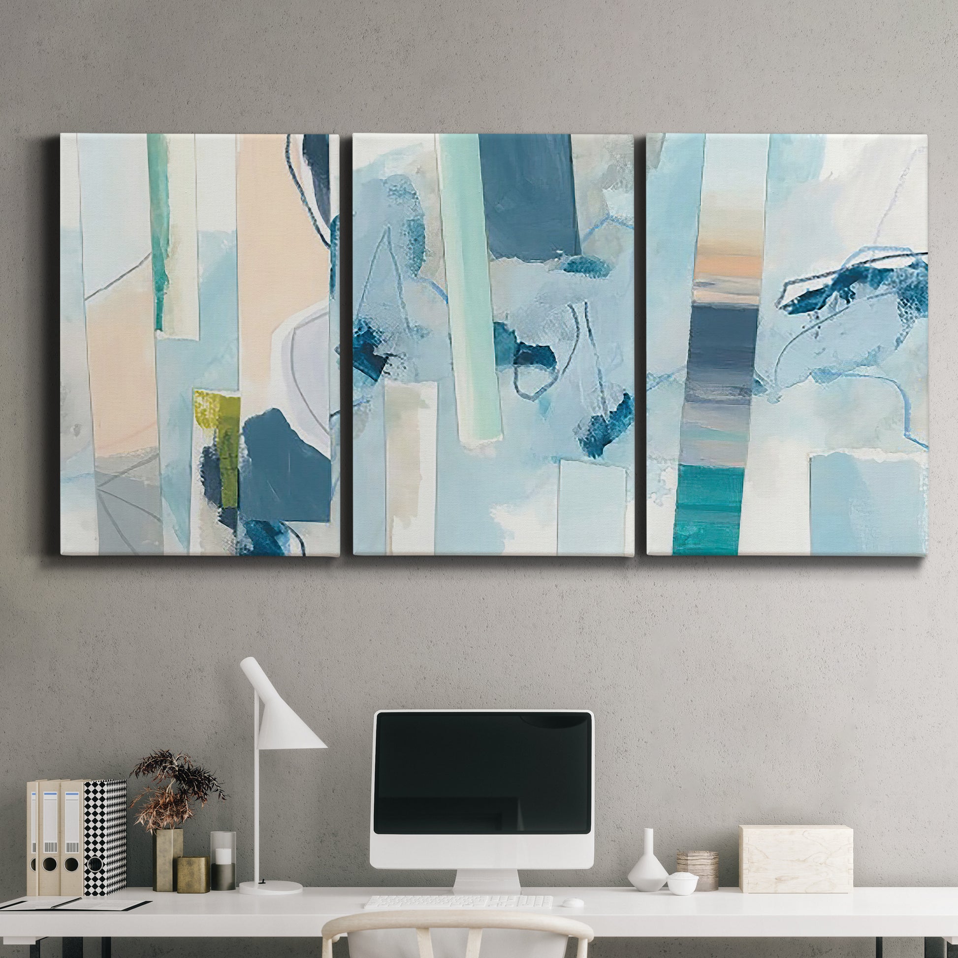 Three-panel canvas wall art featuring layered geometric abstract strata forms, displayed above a desk in a home office.