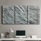 Three-panel canvas wall art featuring coastal shoreline with gentle surf, displayed above a desk in a home office.