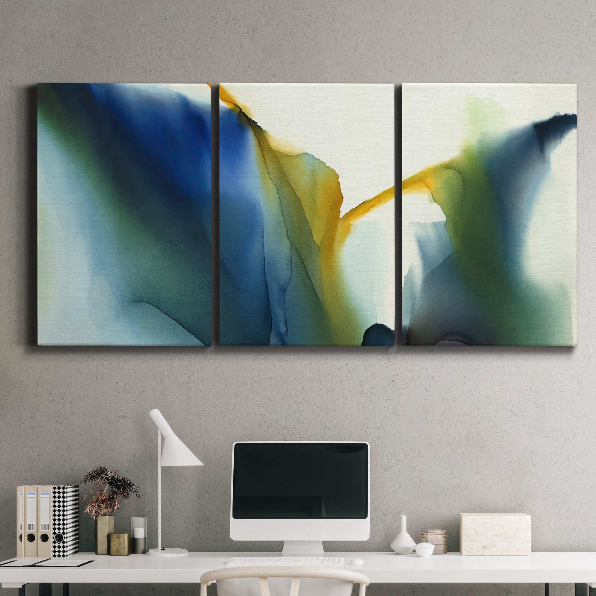 Three-panel canvas wall art featuring soft abstract mask like forms, displayed above a desk in a home office.