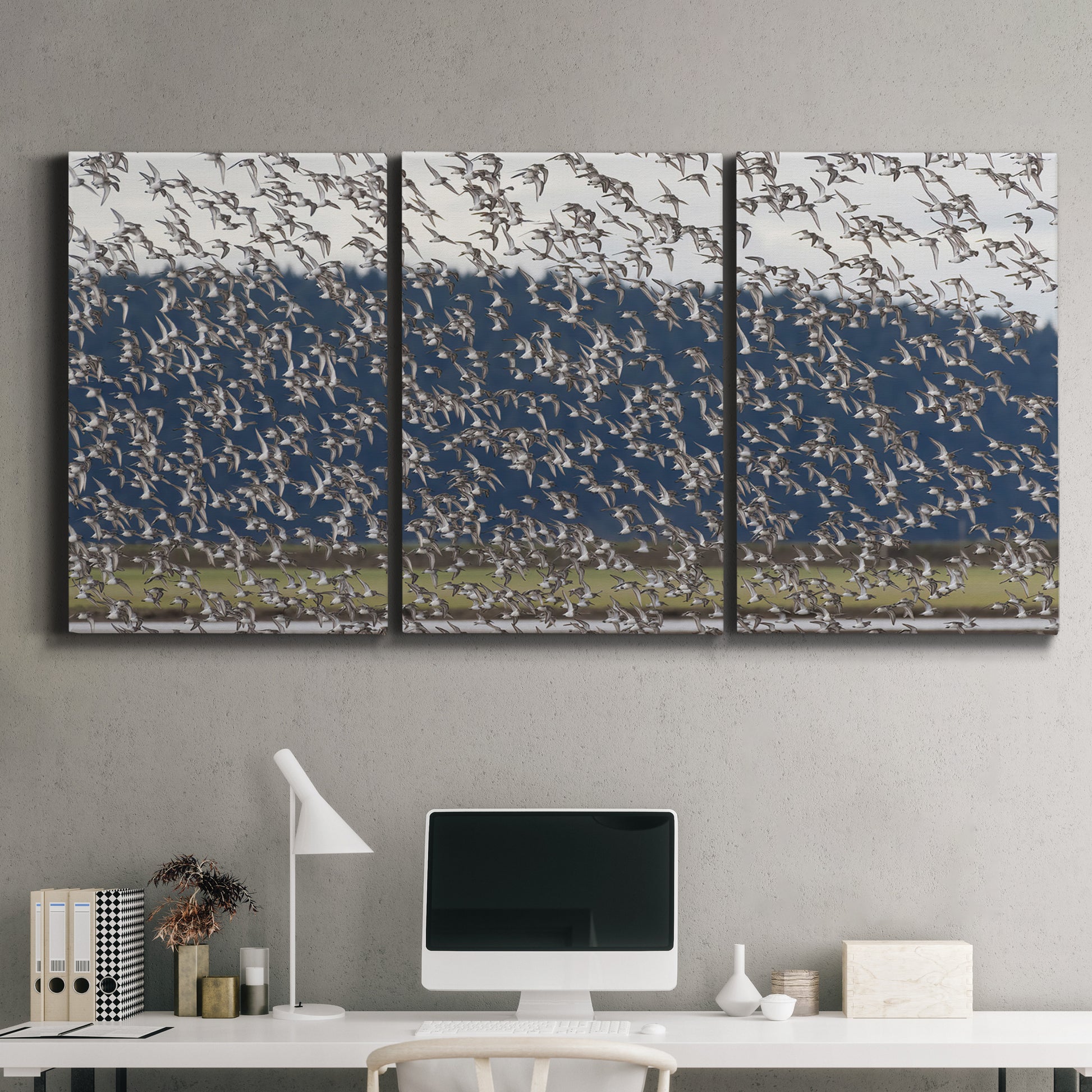 Three-panel canvas wall art featuring group of animals in open field, displayed above a desk in a home office.
