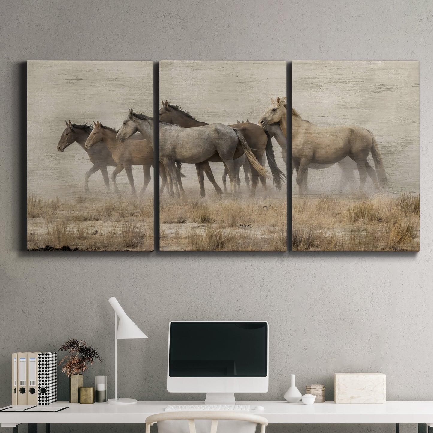 Three-panel canvas wall art featuring wild horses roaming open terrain, displayed above a desk in a home office.