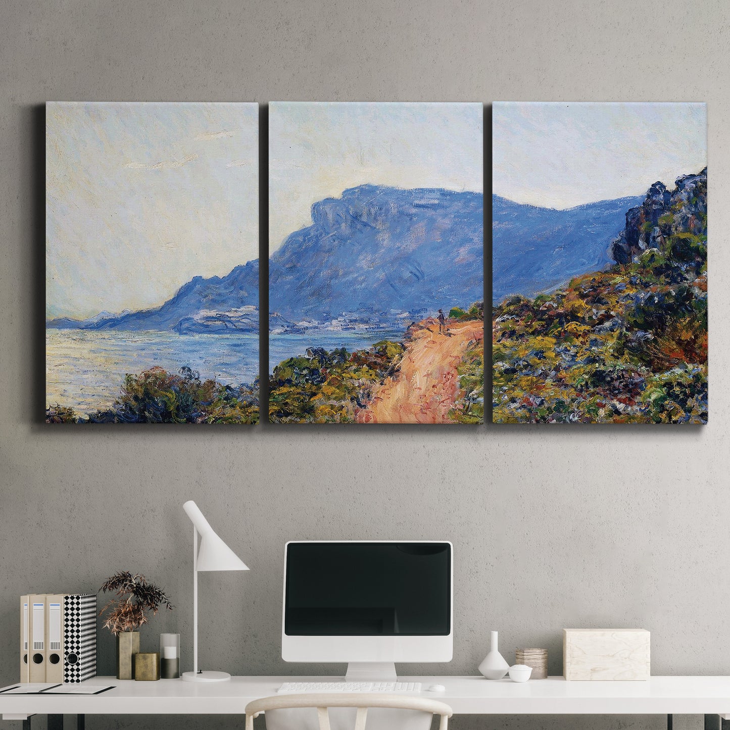 Three-panel canvas wall art featuring winding coastal road above sea, displayed above a desk in a home office.