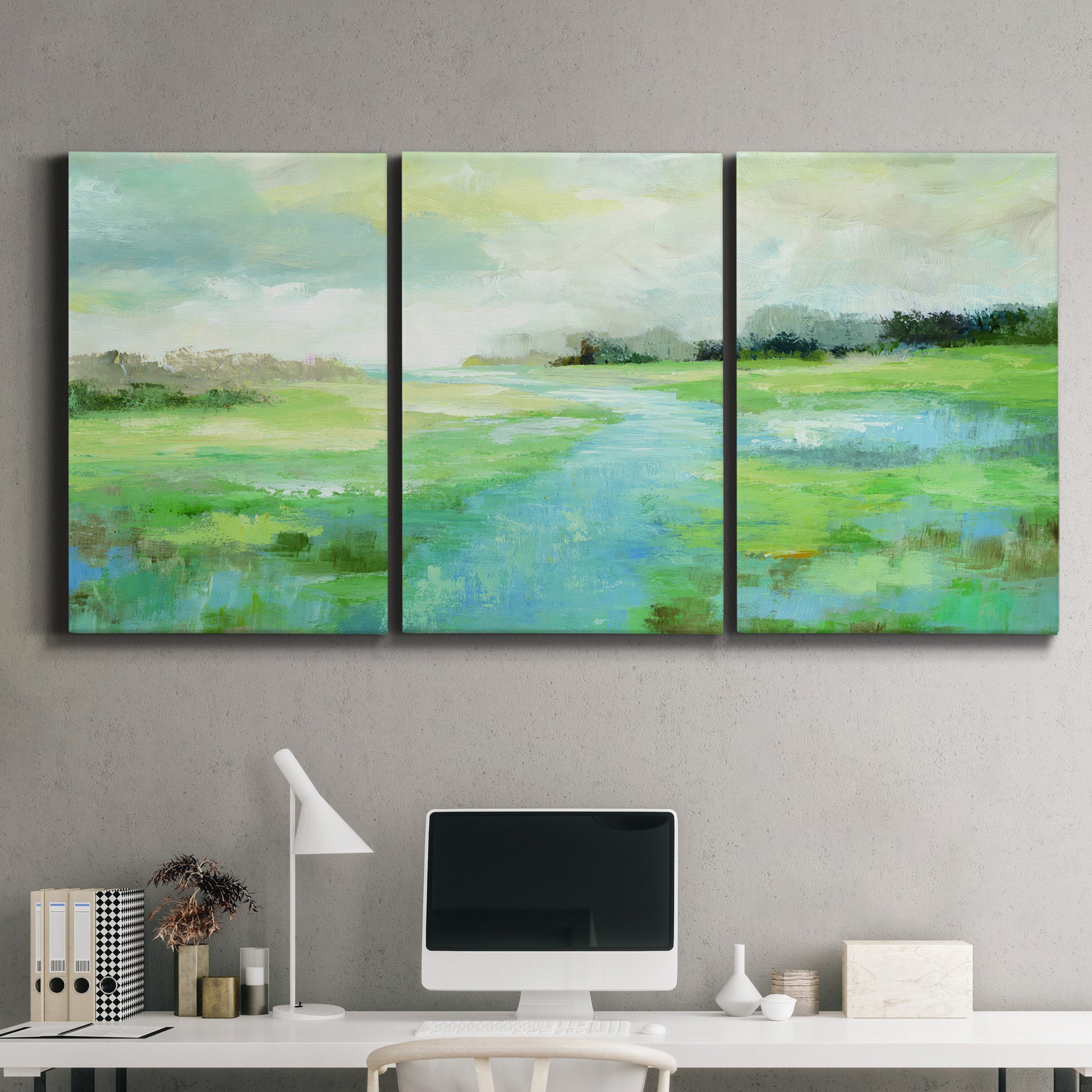 Three-panel canvas wall art featuring gentle stream winding through trees, displayed above a desk in a home office.
