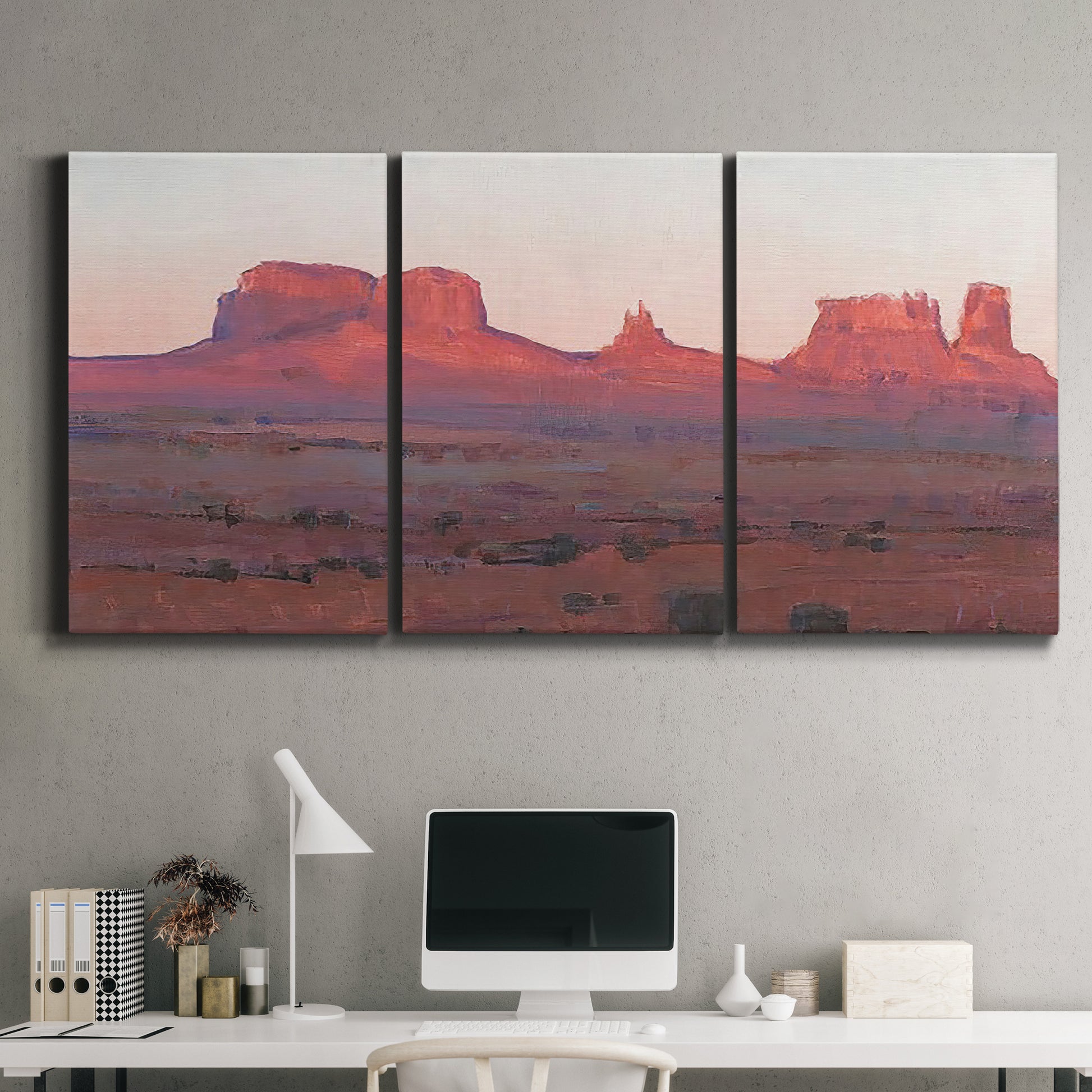 Three-panel canvas wall art featuring red rock desert formations at dusk, displayed above a desk in a home office.