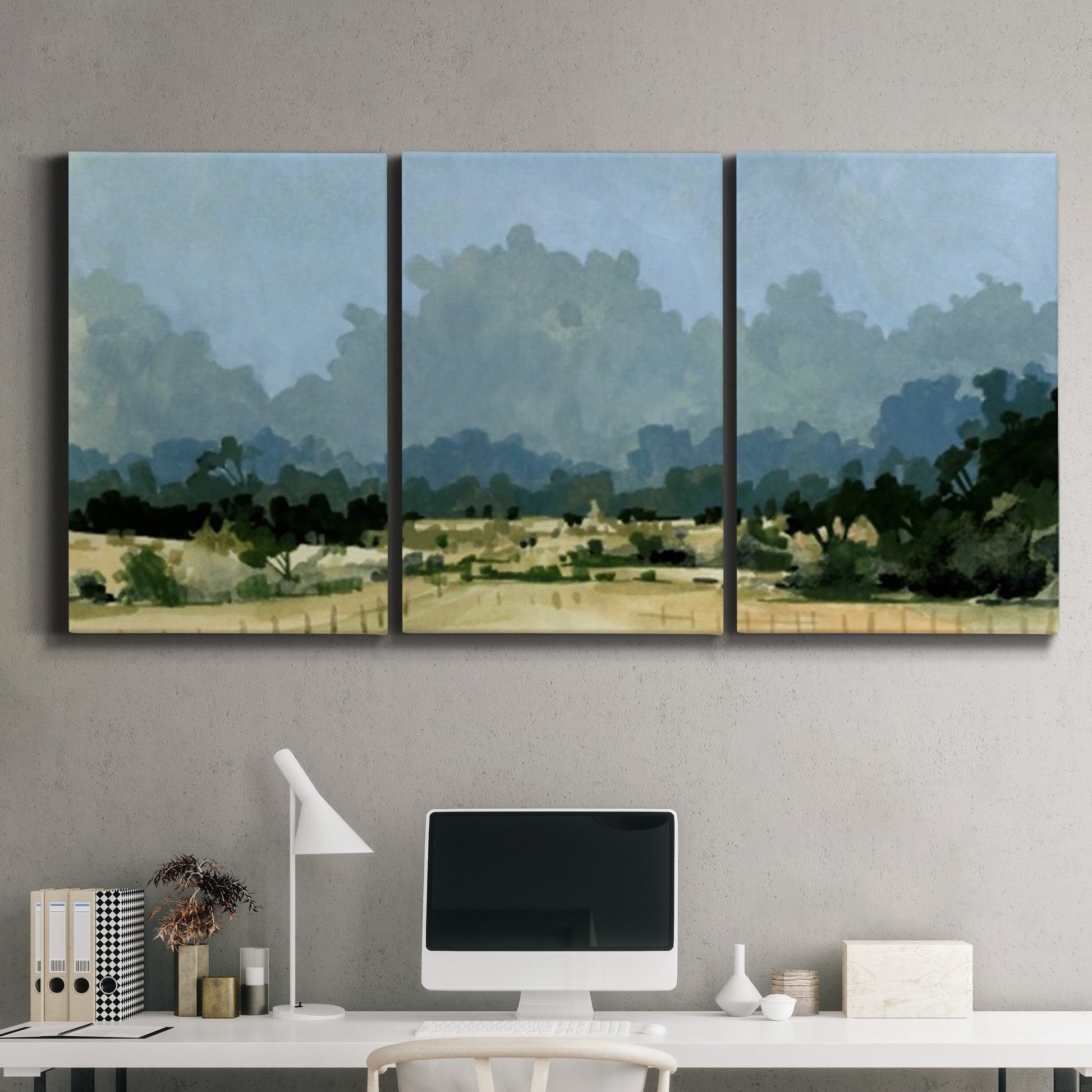 Three-panel canvas wall art featuring rural farmland landscape in watercolor, displayed above a desk in a home office.