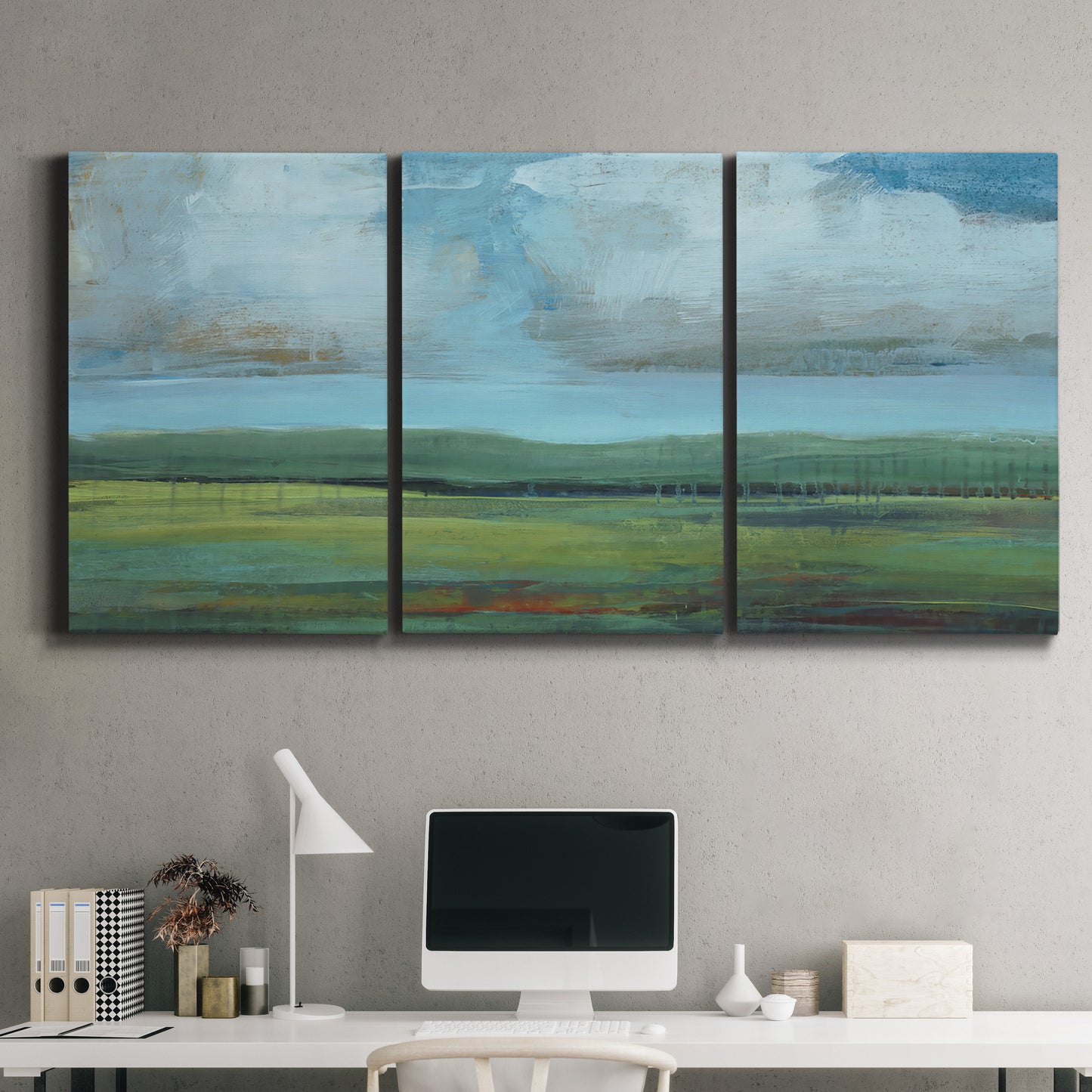 Three-panel canvas wall art featuring wide valley landscape with rolling hills, displayed above a desk in a home office.