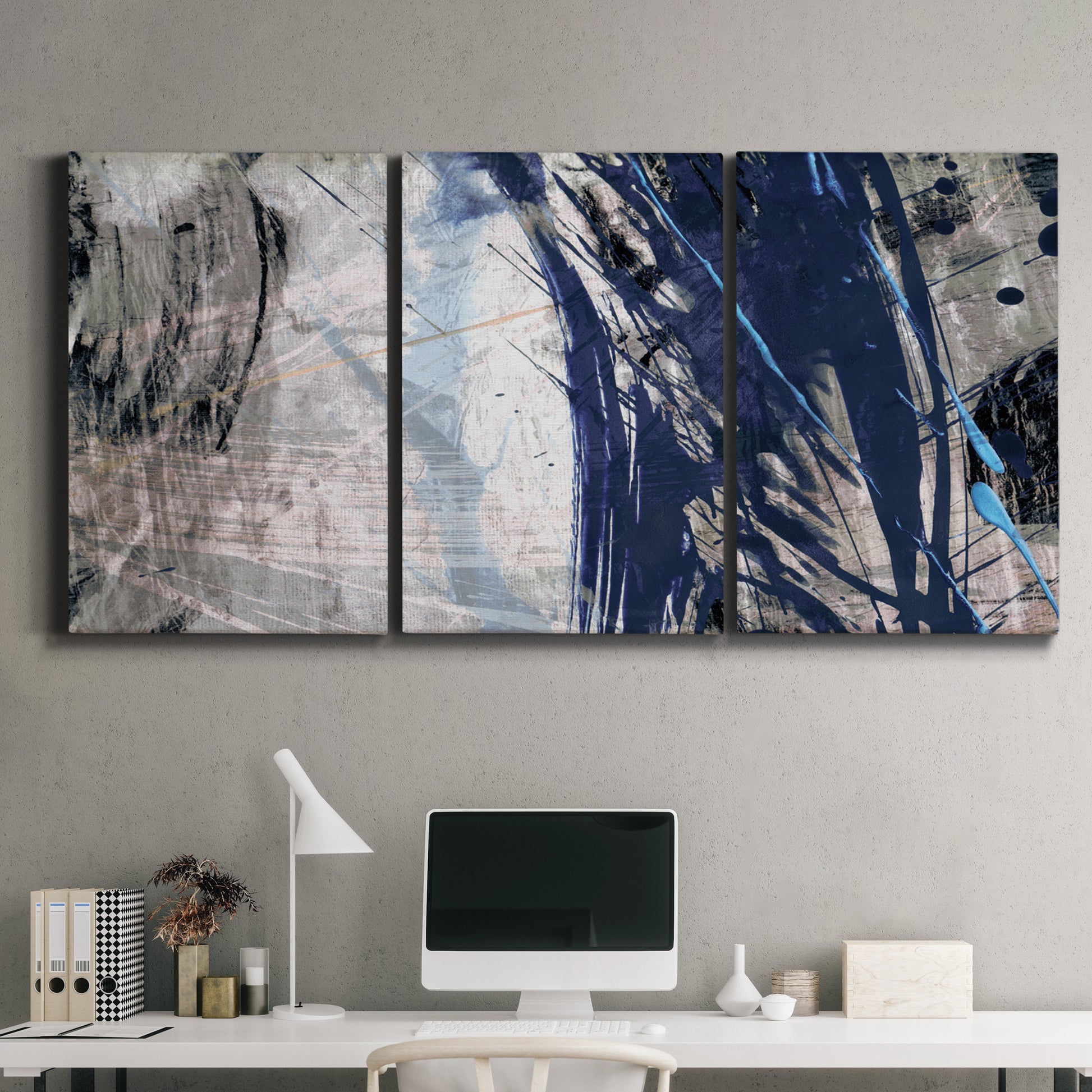 Three-panel canvas wall art featuring layered blue abstract texture, displayed above a desk in a home office.