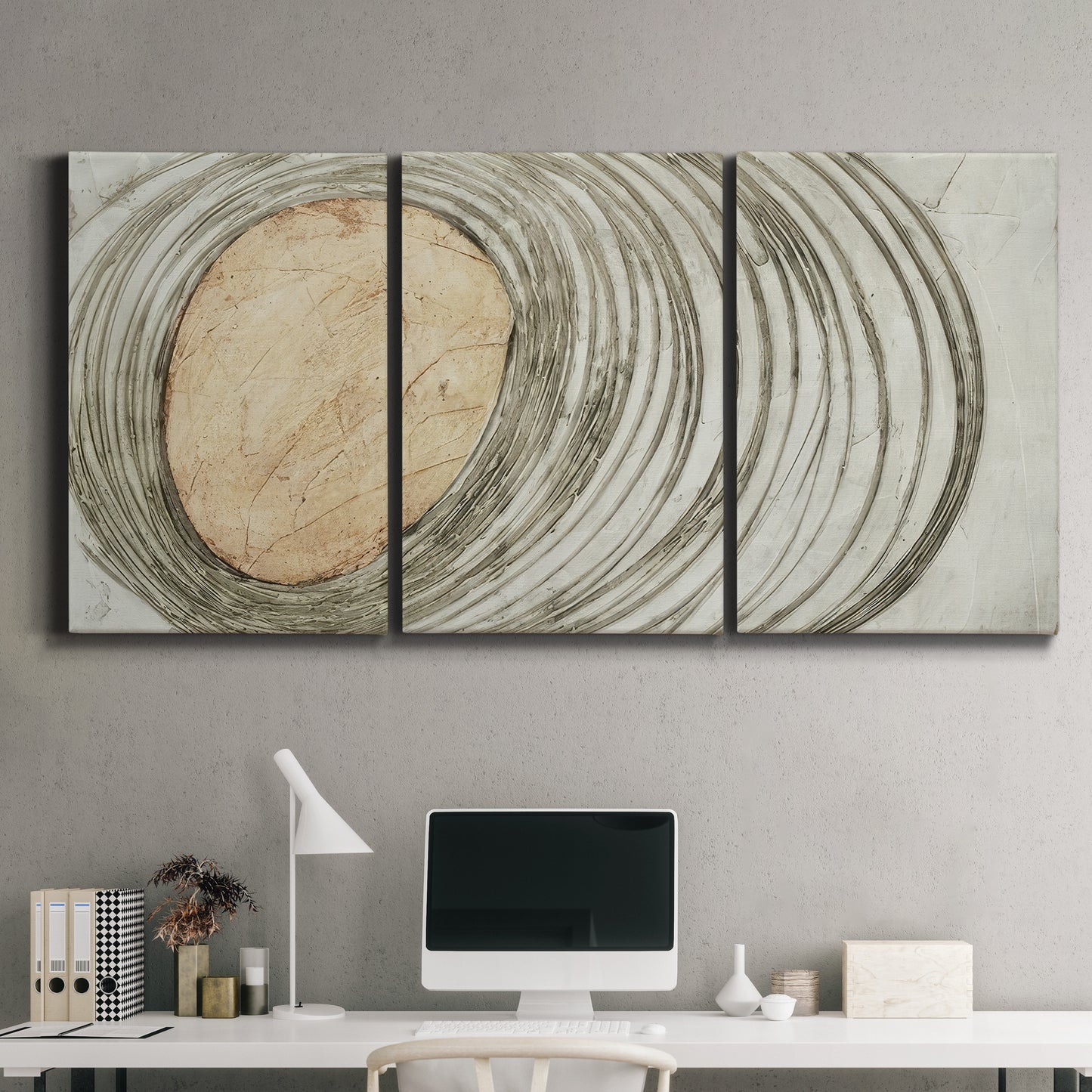 Three-panel canvas wall art featuring circular abstract energy forms, displayed above a desk in a home office.