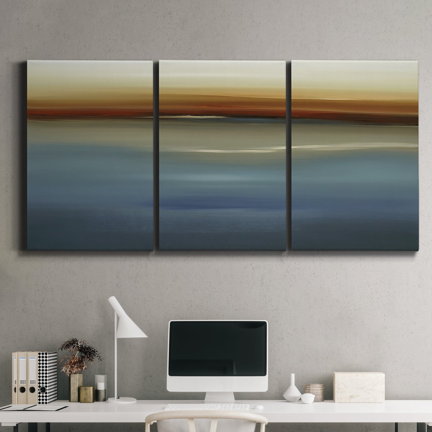 Three-panel canvas wall art featuring horizontal abstract coastal color bands, displayed above a desk in a home office.