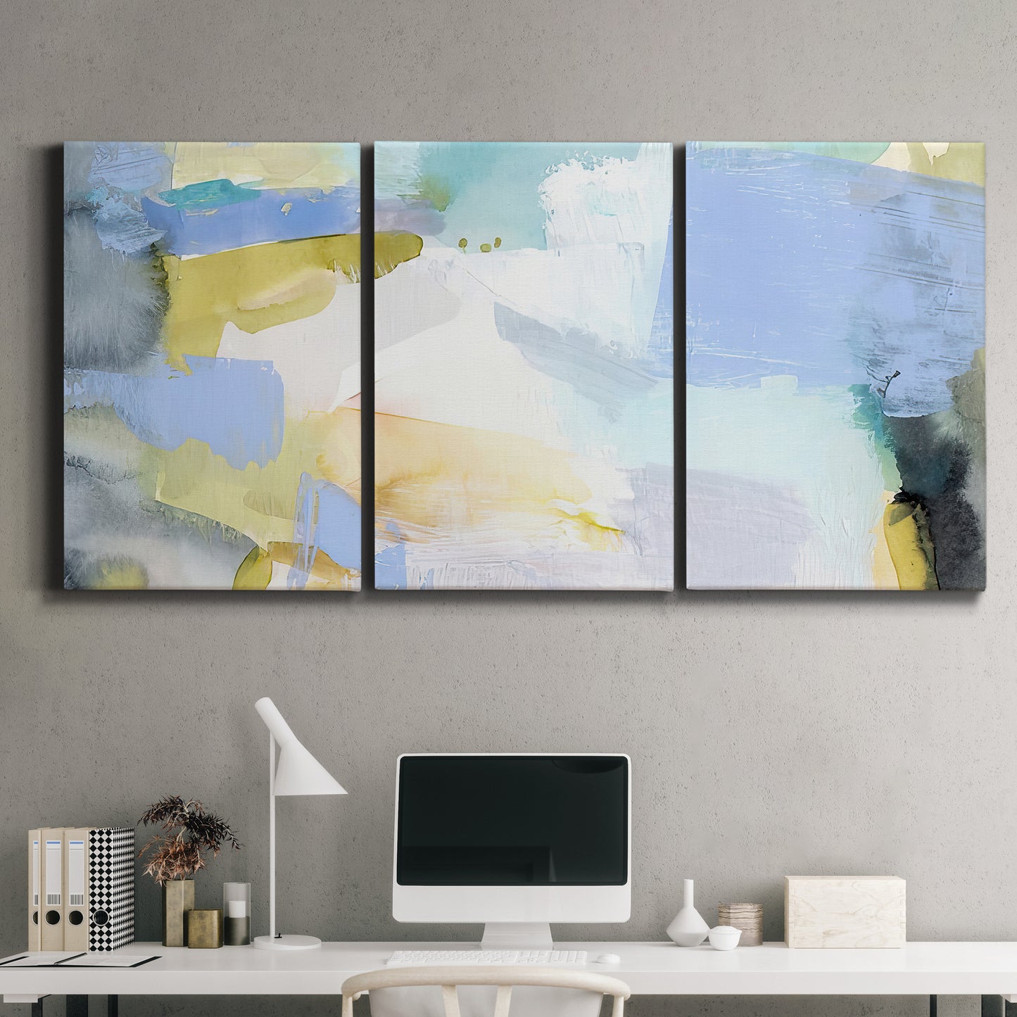 Three-panel canvas wall art featuring soft abstract spring watercolor tones, displayed above a desk in a home office.