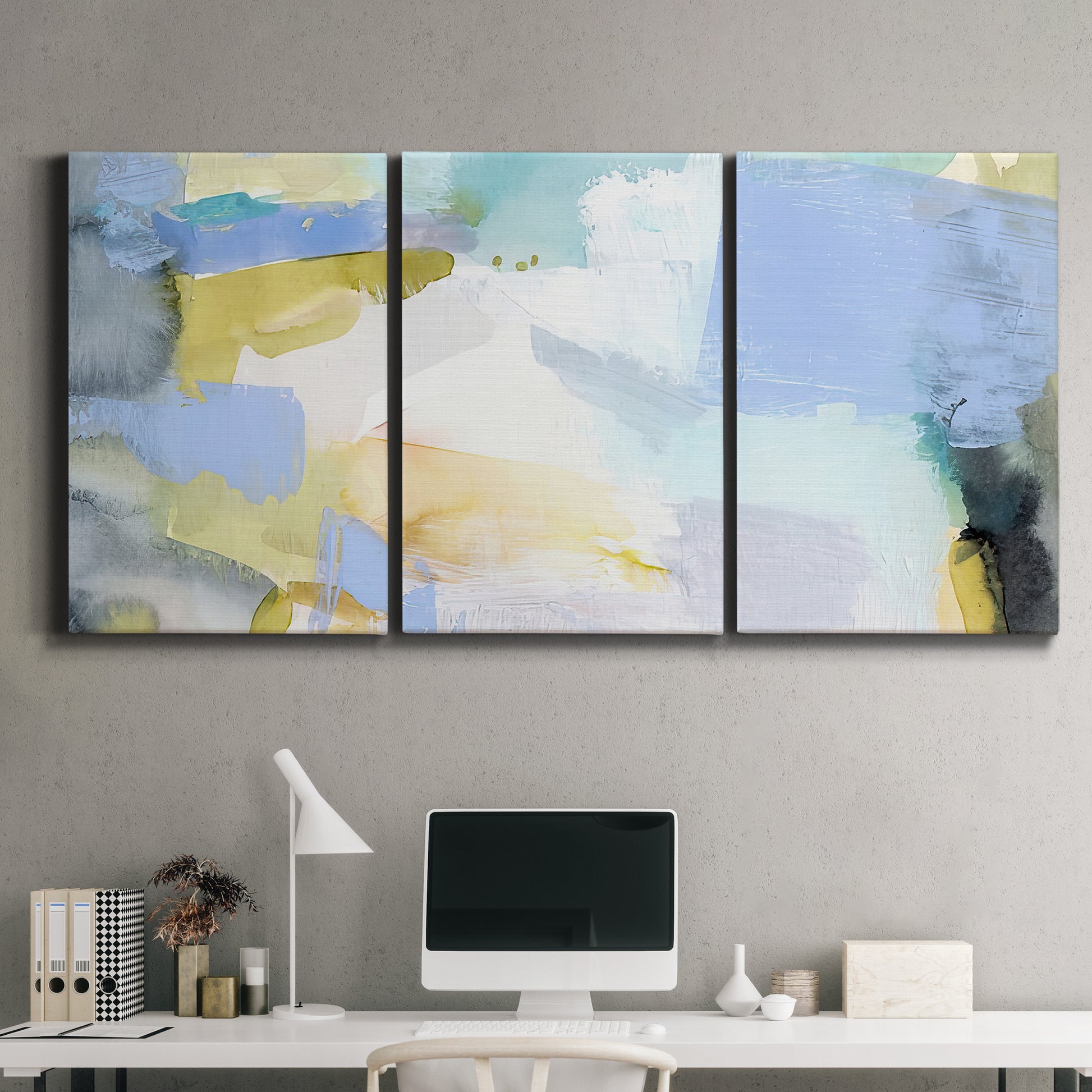 Three-panel canvas wall art featuring soft abstract spring watercolor tones, displayed above a desk in a home office.