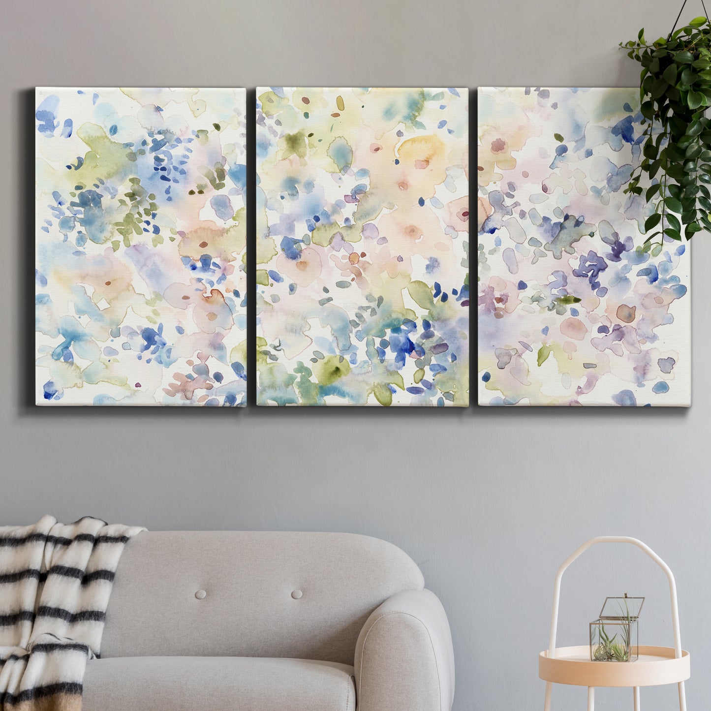 Three-panel canvas wall art featuring flowing abstract watercolor, displayed in a modern living room above a sofa.