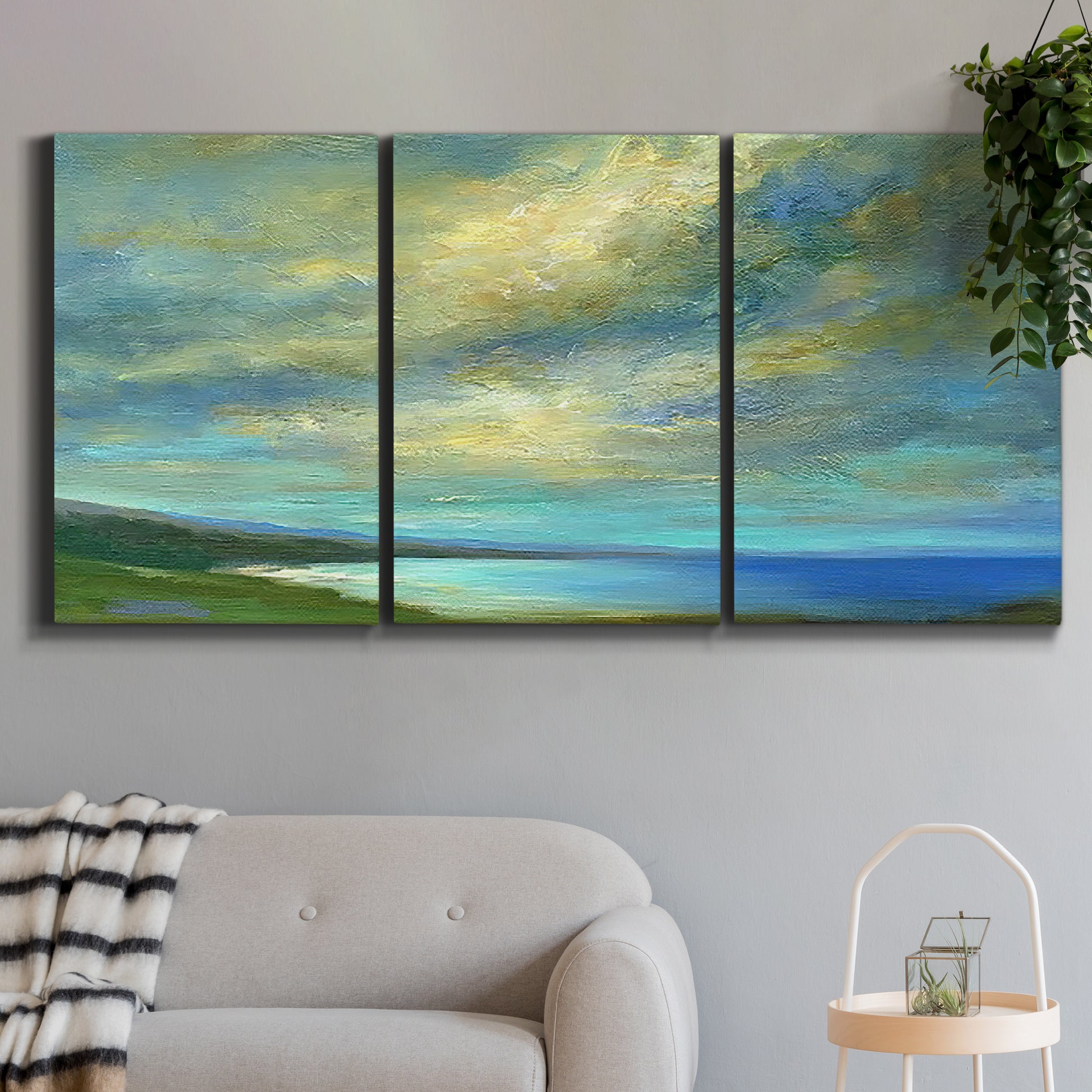Three-panel canvas wall art featuring coastal shoreline with soft waves, displayed in a modern living room above a sofa.