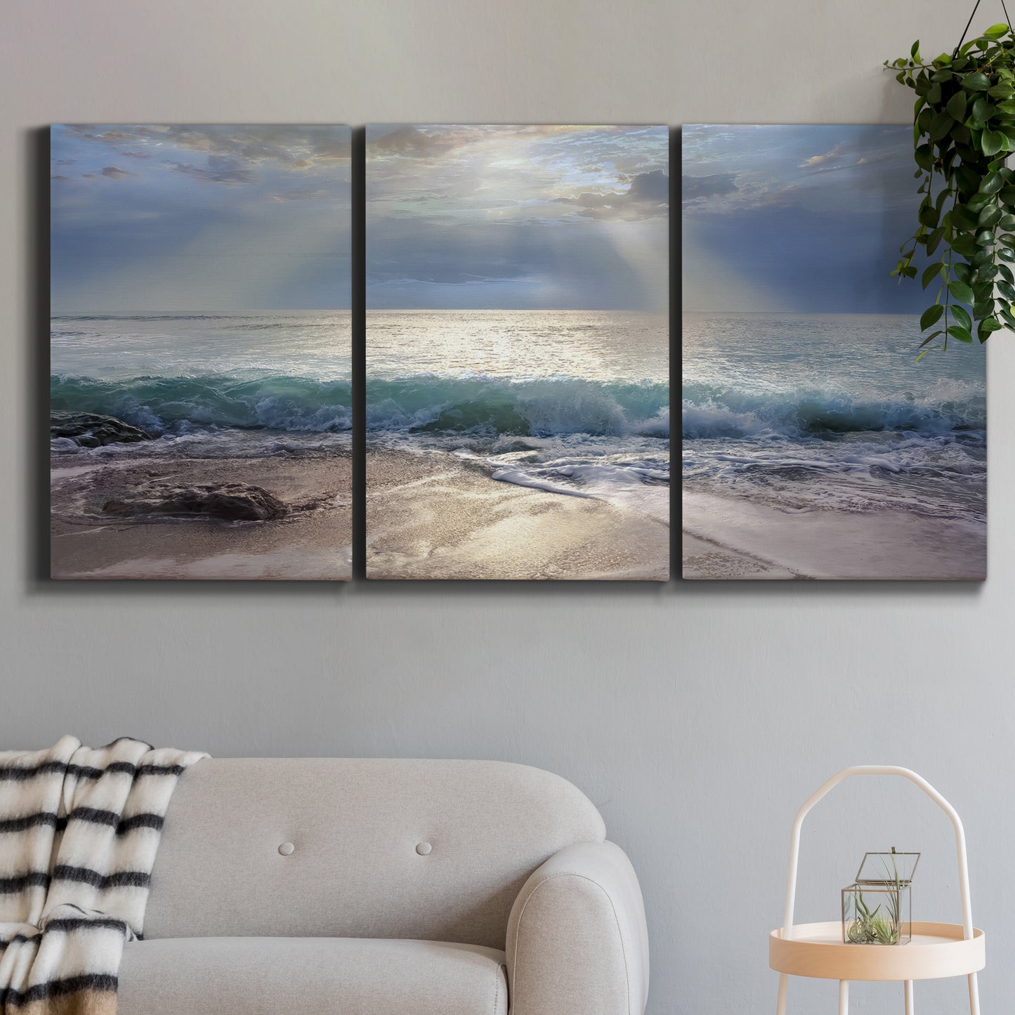 Three-panel canvas wall art featuring soft sunrise over open water, displayed in a modern living room above a sofa.