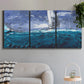 Three-panel canvas wall art featuring sailboats moving across water, displayed in a modern living room above a sofa.