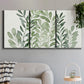 Three-panel canvas wall art featuring foraged leafy greens botanical study, displayed in a modern living room above a sofa.