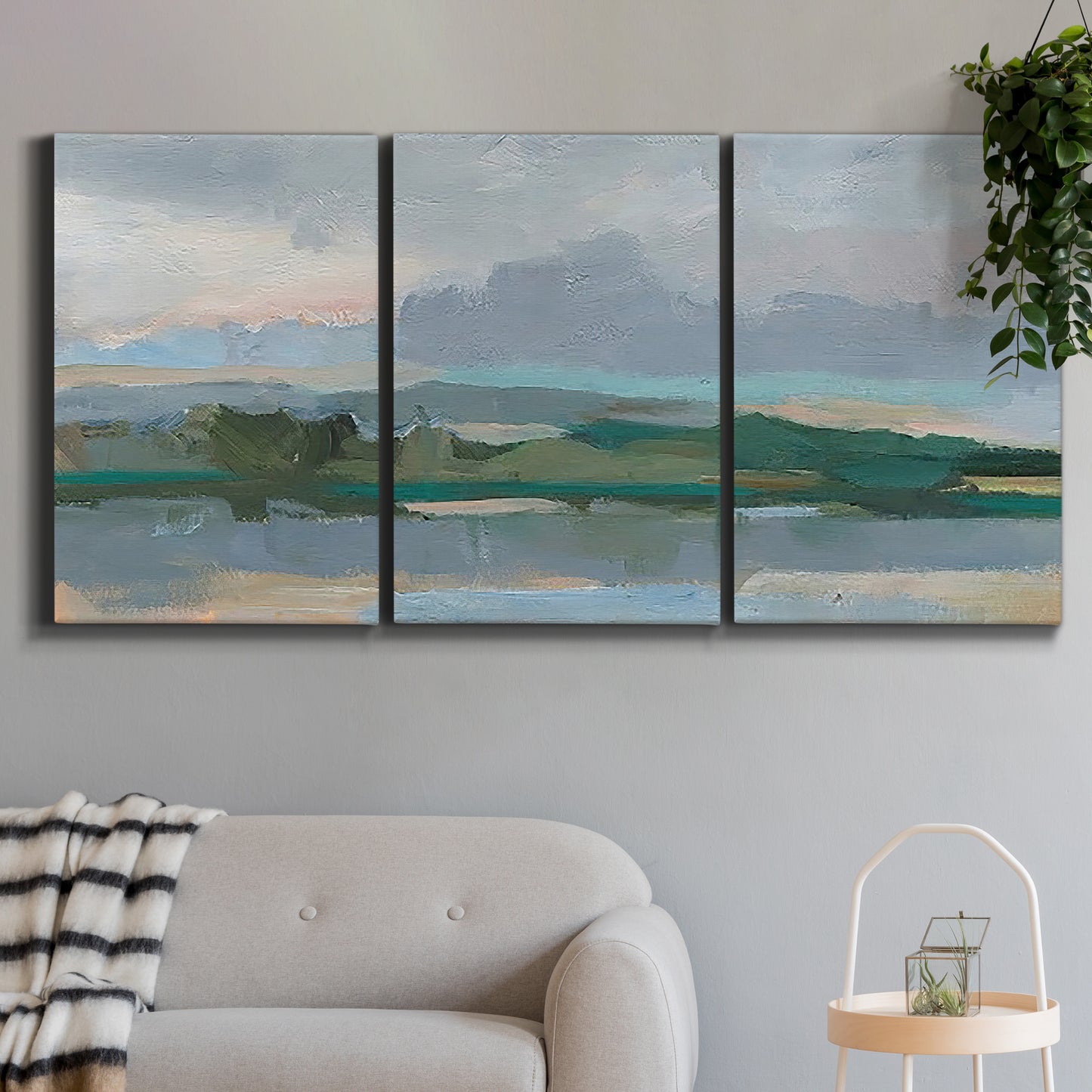 Three-panel canvas wall art featuring twilight landscape with fading light, displayed in a modern living room above a sofa.