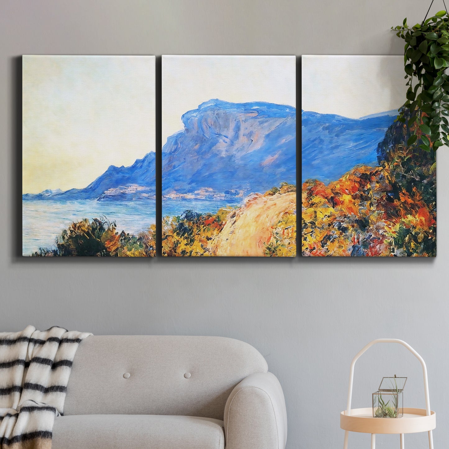 Three-panel canvas wall art featuring winding red road hillside, displayed in a modern living room above a sofa.