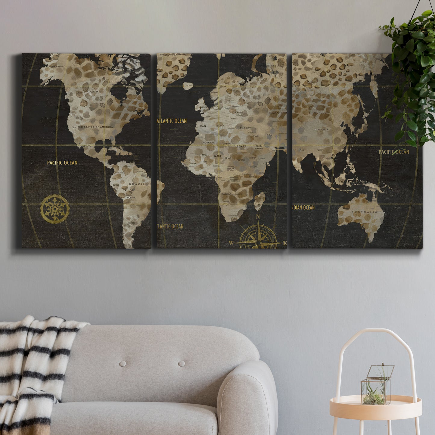 Three-panel canvas wall art featuring illustrated safari world map, displayed in a modern living room above a sofa.